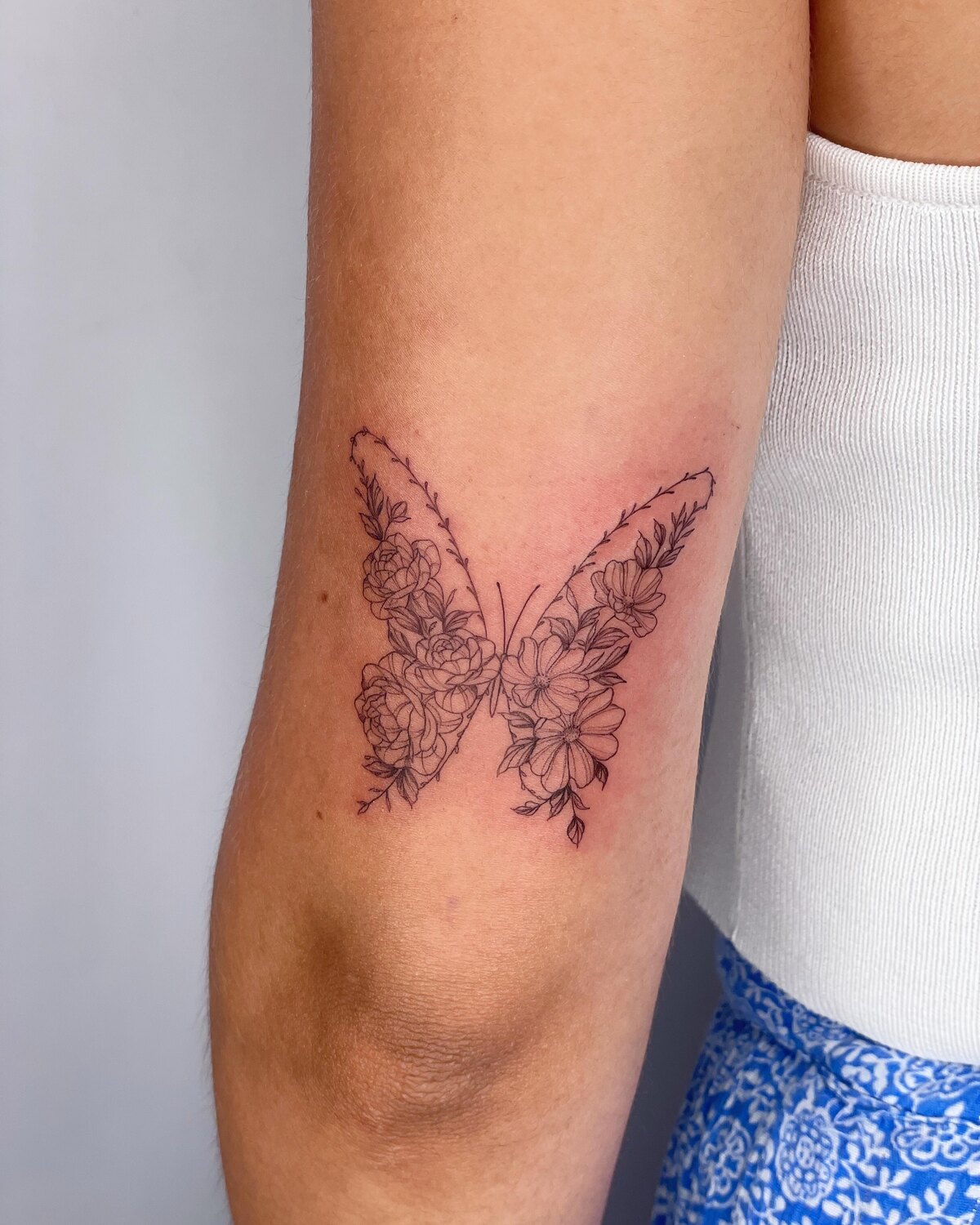 Tatouage papillon fine line sur le bras par Lotty, Bordeaux