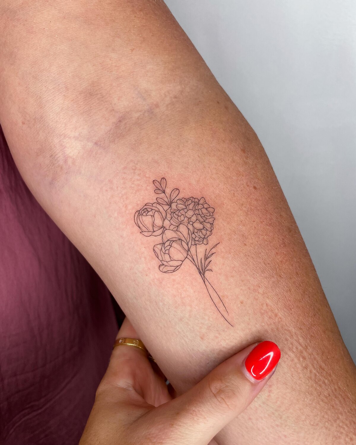 Tatouage floral fine line sur l'avant-bras par Lotty