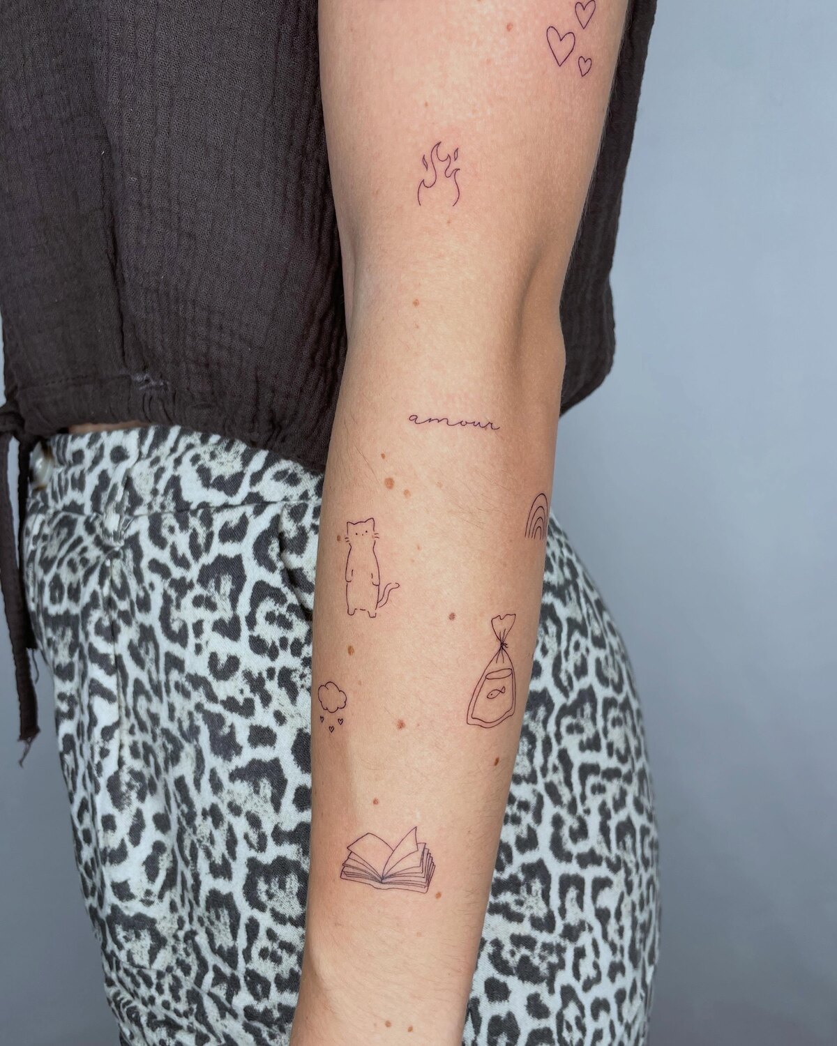 Composition de tatouages minimalistes sur l'avant-bras par Lotty