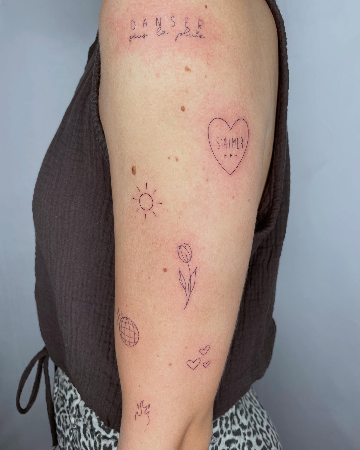 Tatouages floraux minimalistes sur le bras par Lotty